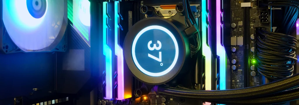 Wnętrze komputera PC z podświetleniem RGB – chłodzenie cieczą procesora z wyświetlaczem temperatury 37°C, podświetlane moduły RAM oraz wentylator obudowy.
